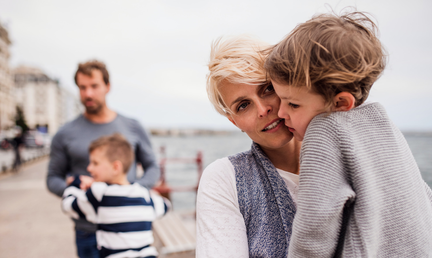 family walking on the boardwalk by the beach