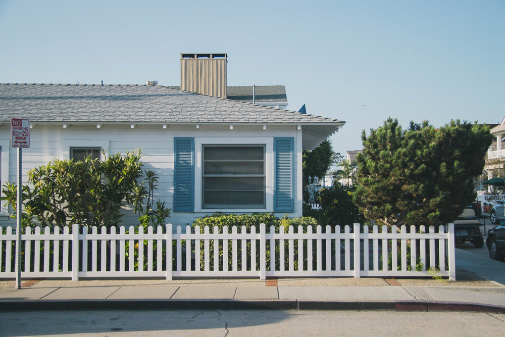 house on the corner with a white fence