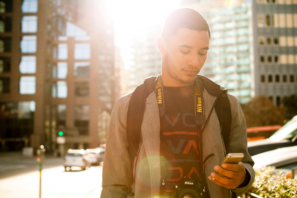 man walking on the street checking mobile phone