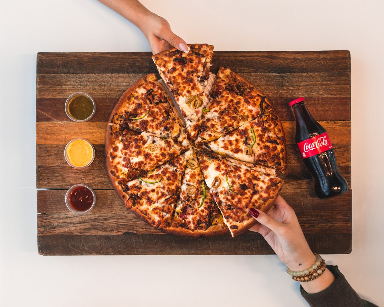 pizza pie next to a bottle of coca-cola