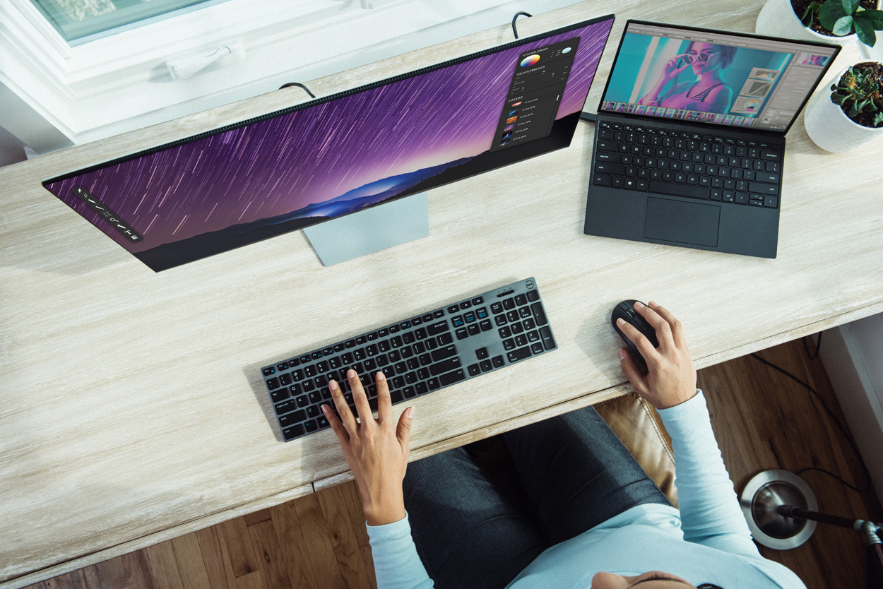 woman sitting at a desk with computers