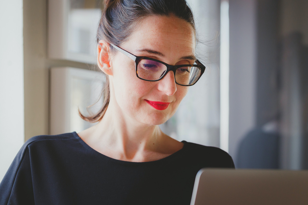 woman with glasses using a computer