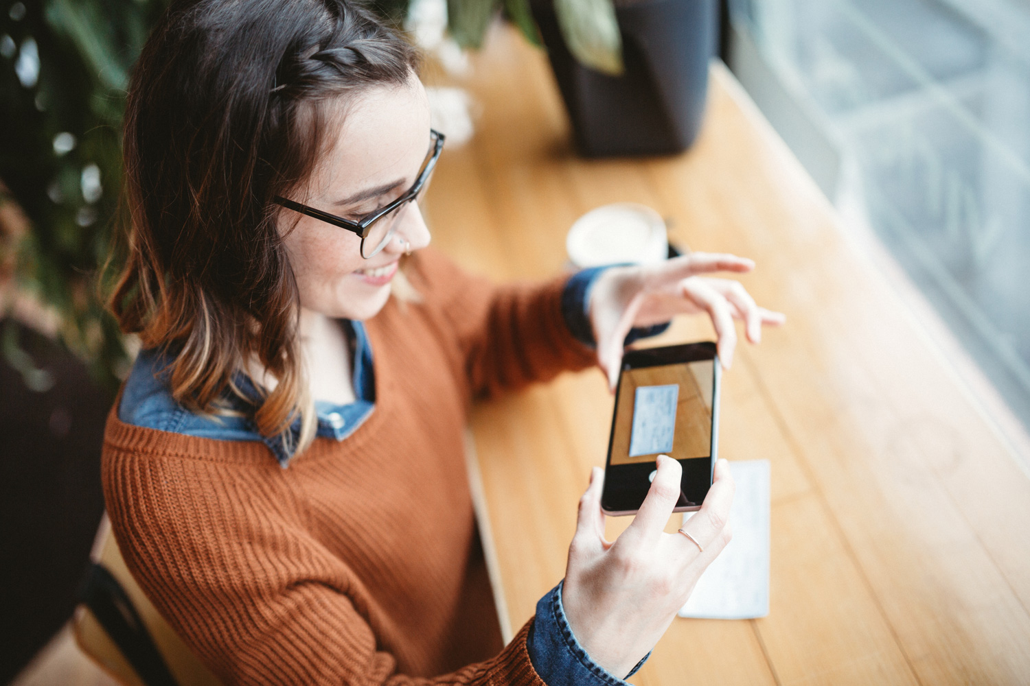 woman taking picture of a check for digital deposit